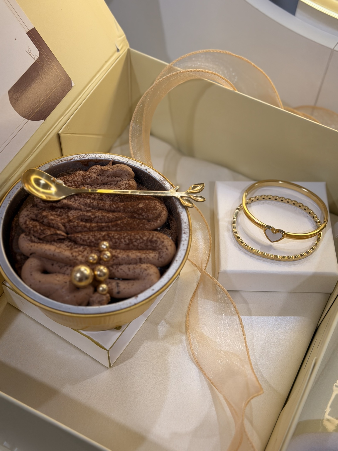 Bread and Bracelet gift packaging with a chocolate mini cake, gold spoon, ribbon and bracelets
