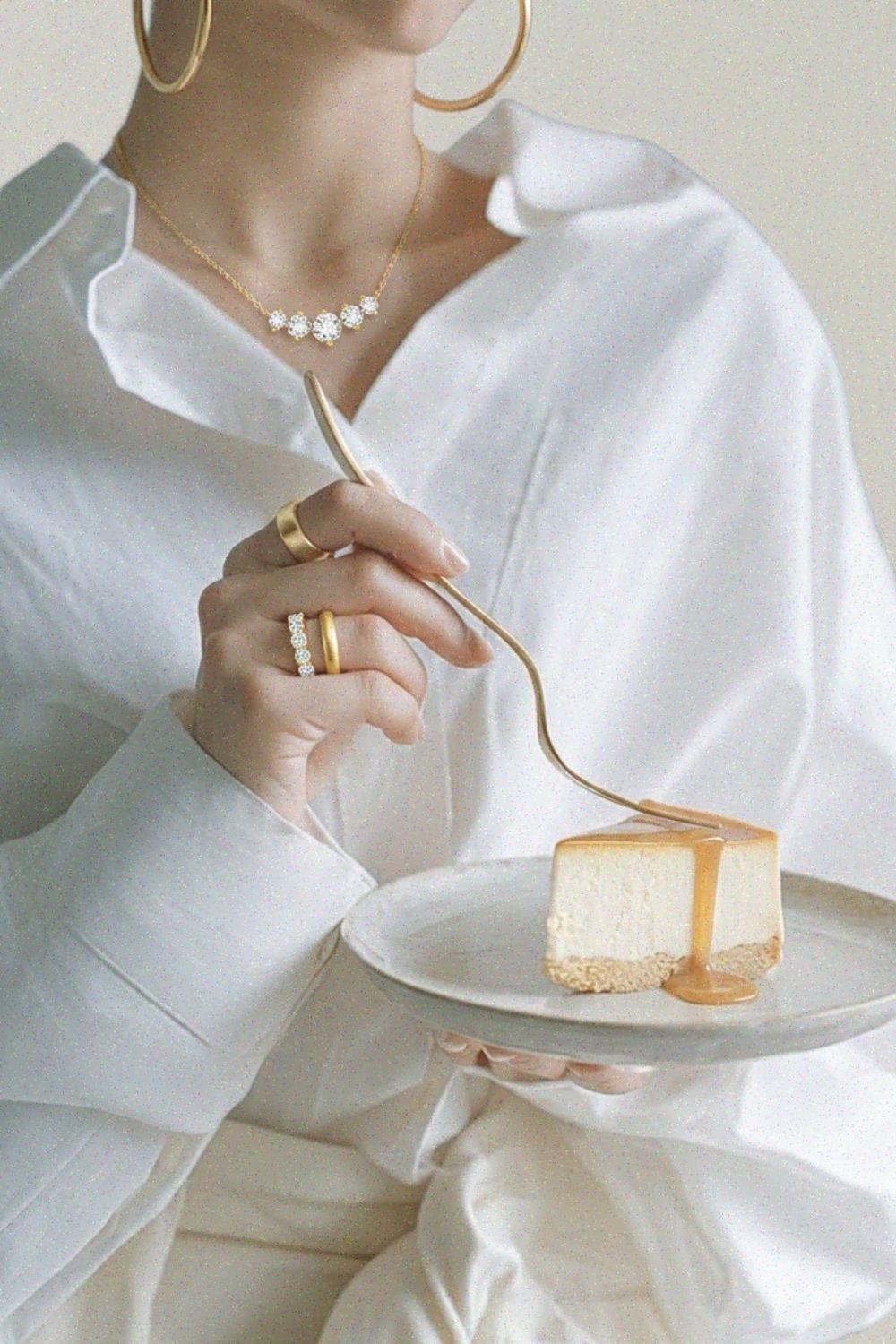 Gold jewellery styled with a cake for an elegant gifting moment